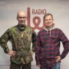 Kenttärovasti Risto Kaakinen ja käsikirjoittaja-dramaturgi Ari-Pekka Lahti Radio Dein logon edessä.