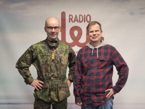 Kenttärovasti Risto Kaakinen ja käsikirjoittaja-dramaturgi Ari-Pekka Lahti Radio Dein logon edessä.