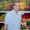 a_happy_man_holding_a_watermelon_in_store