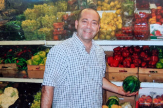 a_happy_man_holding_a_watermelon_in_store