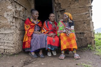 naisia istuu portailla