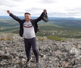 Mies tunturissa kädet ylhäällä vapautuneesti