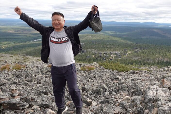 Mies tunturissa kädet ylhäällä vapautuneesti