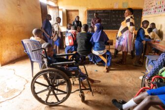 Luokkahuoneessa etualalla poika pyörätuolissa.