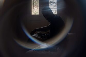 Mies hämärässä huoneessa.