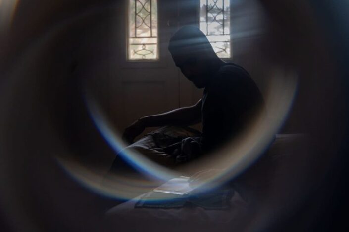 Mies hämärässä huoneessa.