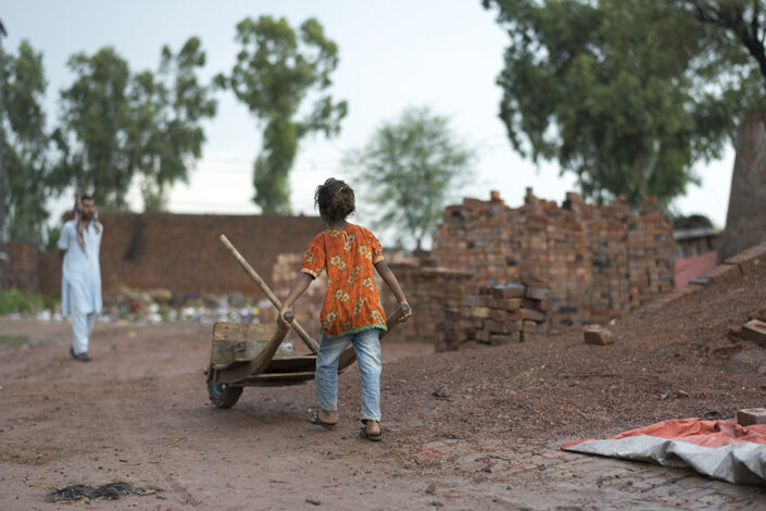 Pieni tyttö työntää kottikärryjä