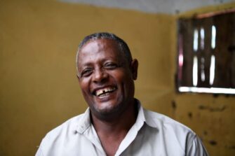 Naurava tummaihoinen mies.