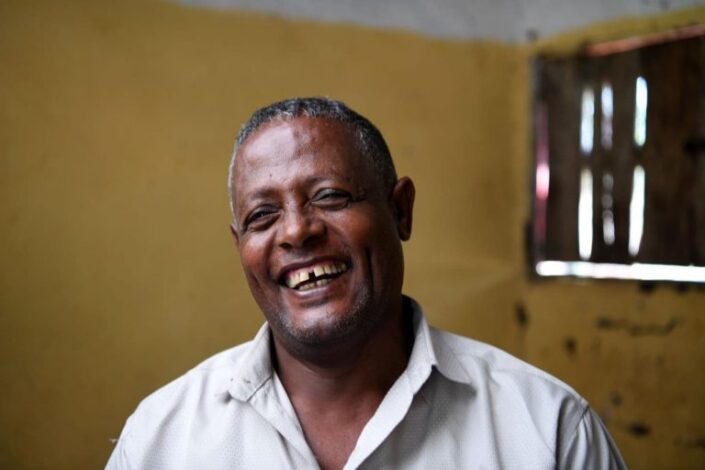 Naurava tummaihoinen mies.