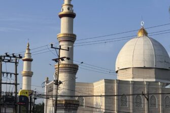 Vaalea moskeija Indonesian kiireisessä katukuvassa.