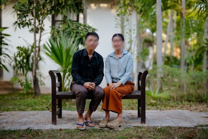 Pariskunta istuu penkillä ulkona.