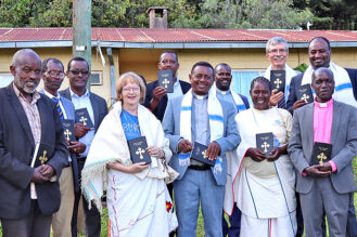 Mirjami Uusitalo diraitankielisen Uuden testamentin käyttöönottojuhlassa. Kuvassa on myös paikallisia työtovereita.