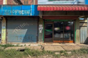 Seinässä autotallin kiinni oleva ovi sekä liikehuoneiston ikkunoita.