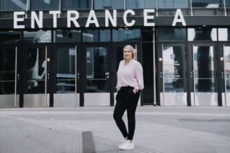 Johanna Vauto seisoo sisäänkäynnin edessä.