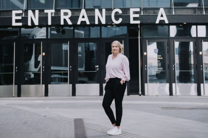Johanna Vauto seisoo sisäänkäynnin edessä.