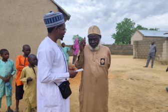 Nigerialainen evankelista jakaa ääniraamattuja kylässä