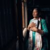 Nepalilainen nainen pitelee Raamattua rintaansa vasten.