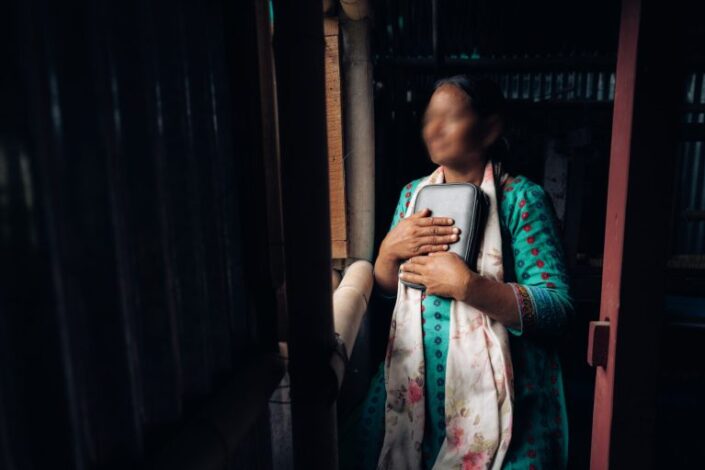 Nepalilainen nainen pitelee Raamattua rintaansa vasten.