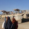 Somalinaisia sodassa tuhoutuneen rakennuksen ohi.