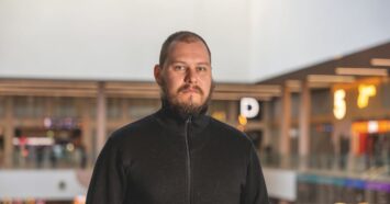 Mies kauppakeskuksessa katsoo suoraan kameraan