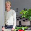Nainen kirkossa katsoo kameraan ja hymyilee