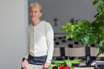 Nainen kirkossa katsoo kameraan ja hymyilee