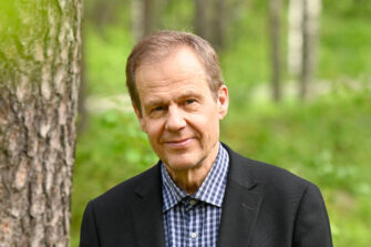 a-man-standing-outside-in-nature-and-smiling